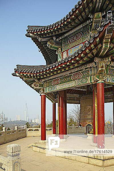 Ein traditioneller Glockenturm-Pavillon im Jiuhuashan-Tempel mit der modernen Stadt im Hintergrund  in der Nähe des Xuanwu-Sees  Nanjing  Provinz Jiangsu  China; Jiuhuashan-Tempel  Nanjing  Provinz Jiangsu  China.