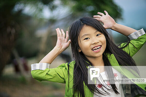 Mädchen macht eine lustige Geste im Spiel und schaut in die Kamera; Hongkong  China