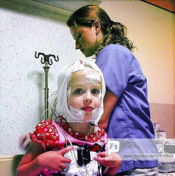 A three year old girl wired for sleep study with her nurse at Childrens Hospital  Washington DC.; District of Columbia.