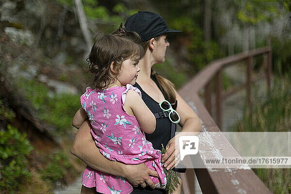 Eine Mutter hält ihre kleine Tochter während einer gemeinsamen Wanderung im Smuggler Cove Marine Provincial Park an der Sunshine Coast von BC  Kanada; British Columbia  Kanada