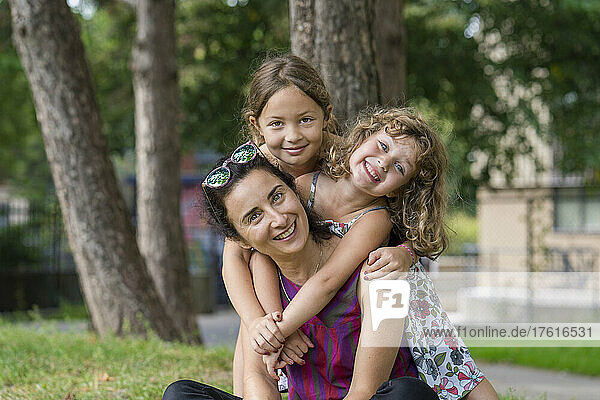 Portrait of a mother with two young daughters in a park; Toronto  Ontario  Canada