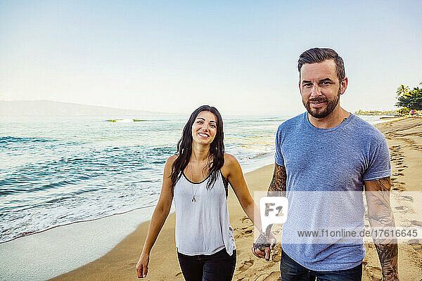 Portrait of a couple walking down Ka'anapali Beach holding hands; Ka'anapali  Maui  Hawaii  United States of America