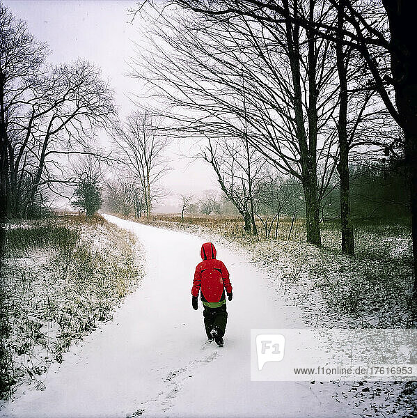 A nine year old boy walks a snow covered road near Timberland Ski area.; Canaan Valley  West Virginia.