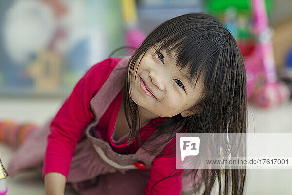 Porträt eines auf dem Boden liegenden kleinen Mädchens; Hongkong  China