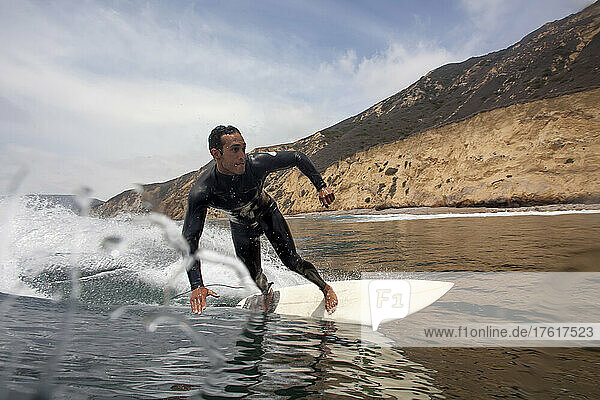 Ein Surfer macht eine Bottom Turn im kalten Wasser der Kanalinseln.