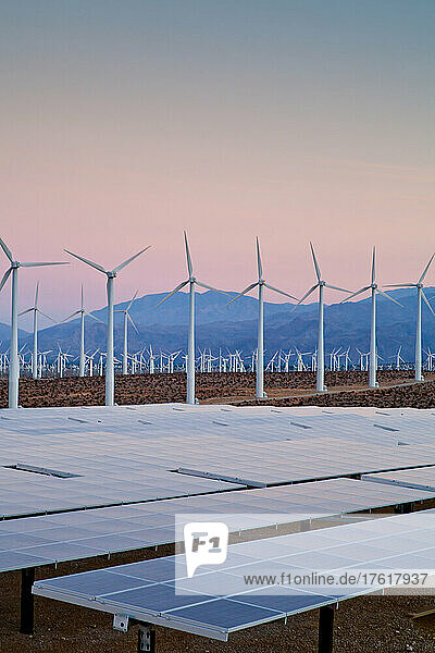 Umweltfreundliche Wind- und Solarenergiegewinnung in der Wüste in der Abenddämmerung.