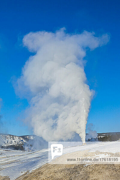 Steam rises from a large natural geyser.