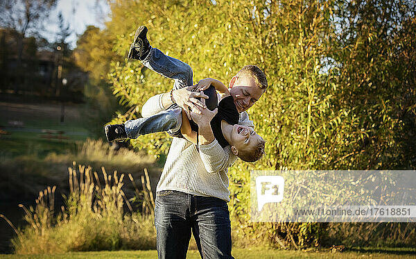 Vater spielt mit seinem kleinen Sohn in einem Park im Herbst; St. Albert  Alberta  Kanada