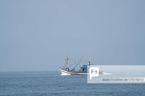 Fishing boat out on the Arabian Sea off Cabo de Rama Beach at Cabo Serai  South Goa  India; Cabo de Rama  Goa  India