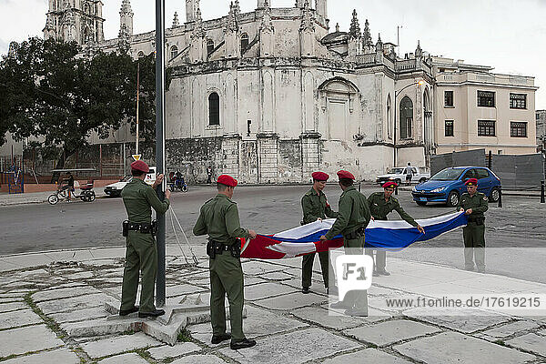 Mehrere Soldaten falten eine kubanische Flagge in der Innenstadt von Havanna  Kuba; Havanna  Kuba