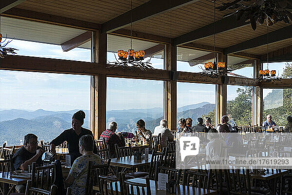 People dining at an Inn with large windows and a view to the Blue Ridge Mountains of North Carolina along the Blue Ridge Parkway; North Carolina  United States of America