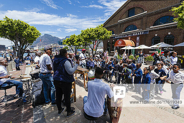 Schulkinder in Uniform halten an  um einer Perkussionsmusikgruppe am Hafen von Kapstadt zuzuhören; Kapstadt  Südafrika