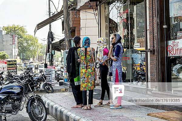 Group of young women standing together on a sidewalk along a street in a city in India; Amritsar  Punjab  India