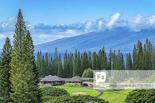 Golfplatz mit Gebäuden und hohen Bäumen auf der Insel Maui  mit den West Maui Mountains im Hintergrund; Kapalua  Maui  Hawaii  Vereinigte Staaten von Amerika
