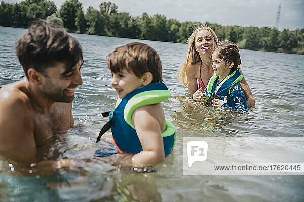 Happy parents playing with children in lake