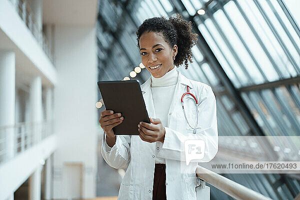 Smiling doctor with tablet PC in hospital