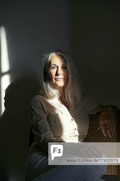Woman with sunlight on her sitting at home