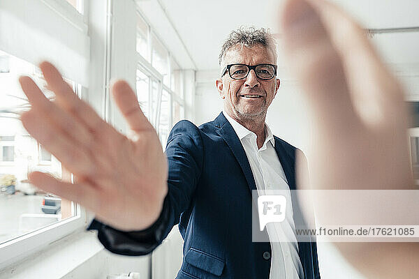 Businessman doing high-five with colleague in office