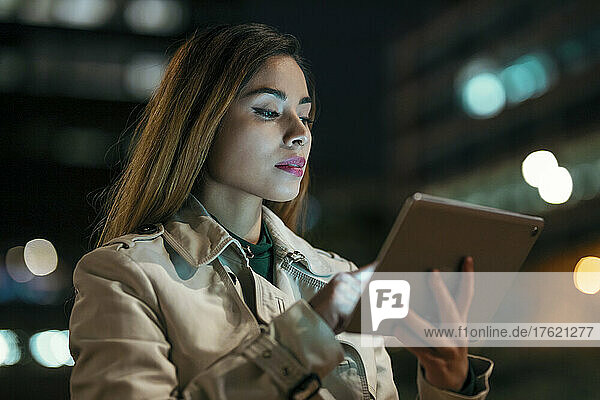 Woman using tablet PC at night