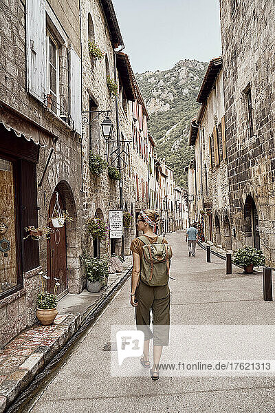 Woman with backpack walking in Villefranche-de-Conflent town