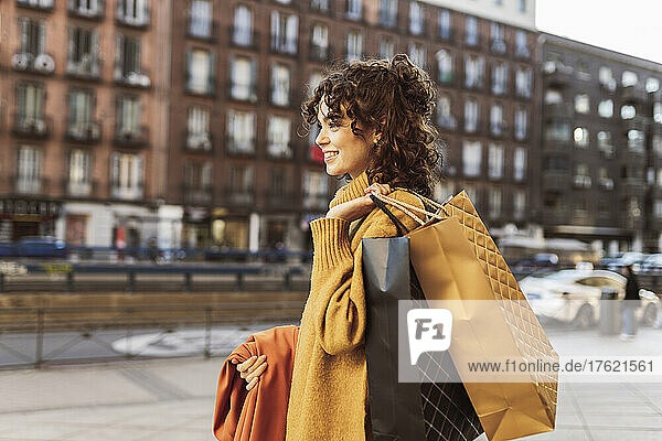 Young woman with shopping bags in city