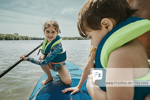 Girl paddleboarding on lake at weekend