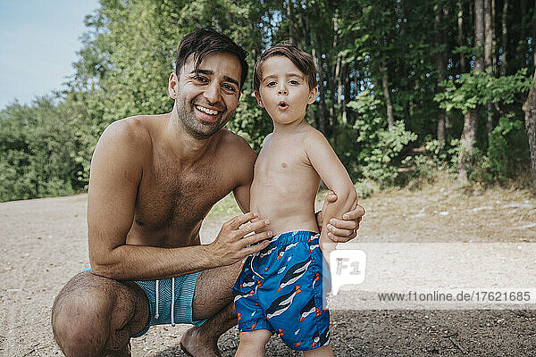 Smiling father and son at lakeshore on weekend