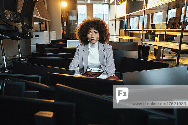 Businesswoman sitting amidst computers at work place