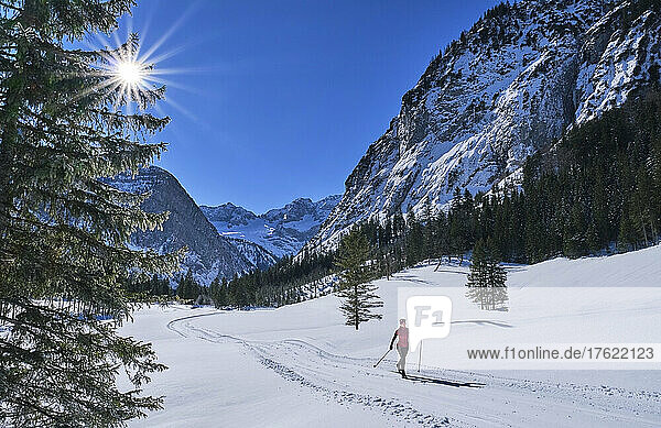 Aktive Seniorin fährt im Schnee an den Bergen Ski