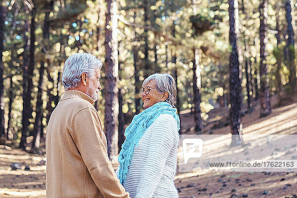 Happy senior couple looking at each other in forest