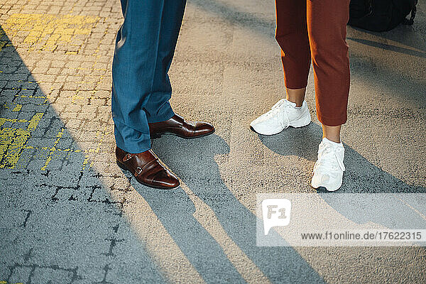 Business colleagues wearing shoes standing on footpath