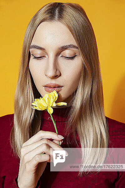 Woman holding flower in studio