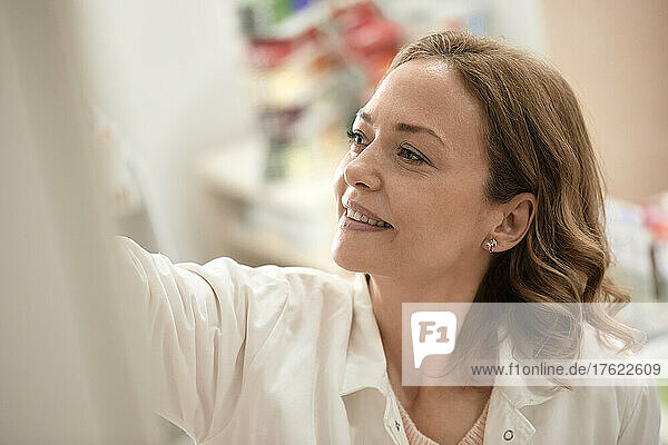 Smiling female pharmacist working in pharmacy