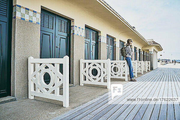 Woman standing in front of beach huts