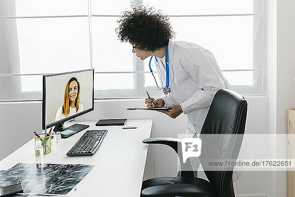 Doctor discussing with patient through video call at medical clinic