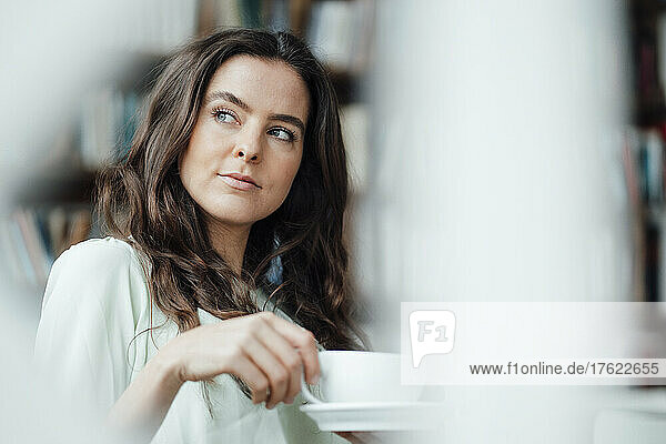 Thoughtful woman with coffee cup in cafe