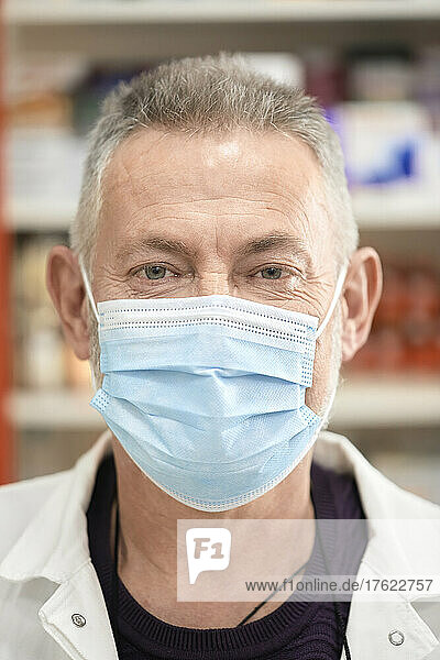 Pharmacist wearing protective face mask at pharmacy store