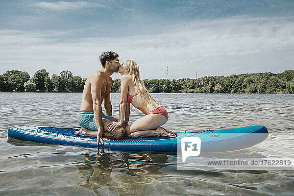 Couple kissing on paddleboard at weekend