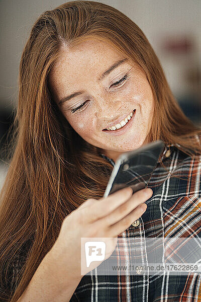 Smiling woman using mobile phone