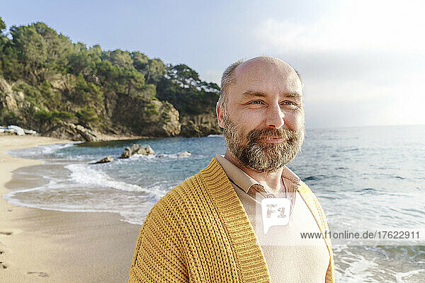 Smiling man contemplating at beach