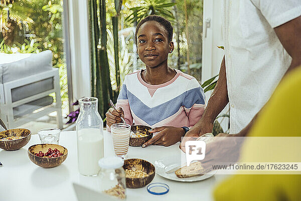 Girl having cereal at breakfast in dining room
