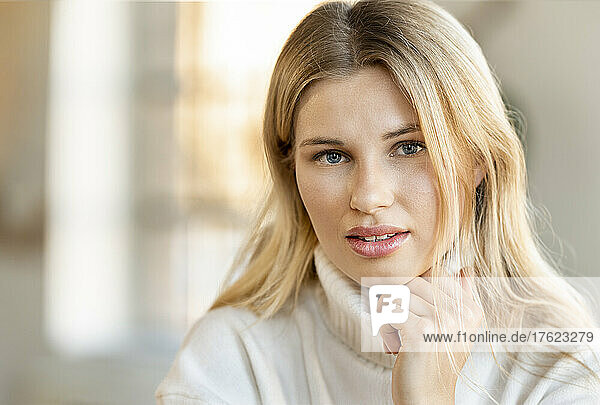 Beautiful blond woman with hand on chin