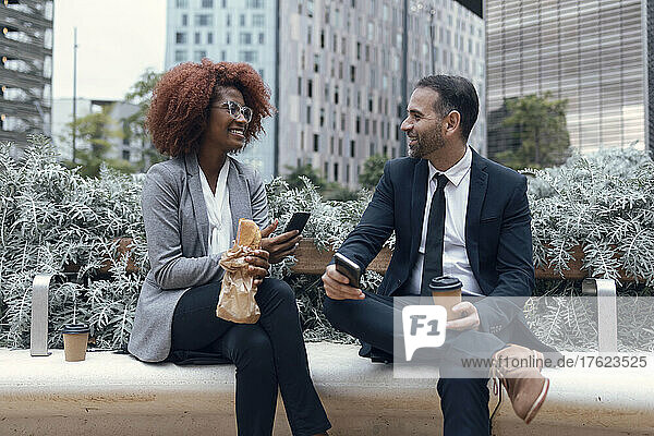 Two business colleagues talking while sitting outdoors