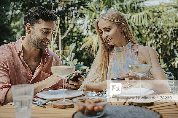 Couple using smart phones at outdoor table