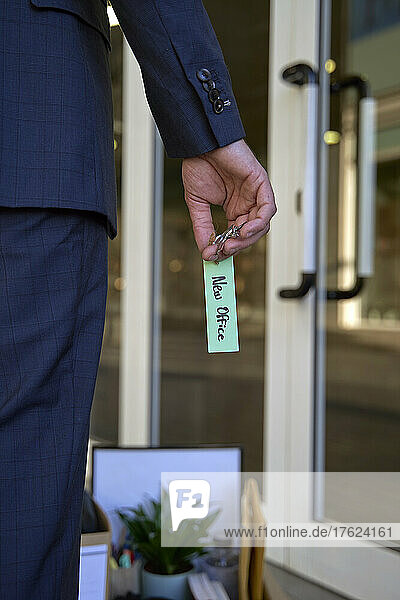 Businessman holding key with label standing in office