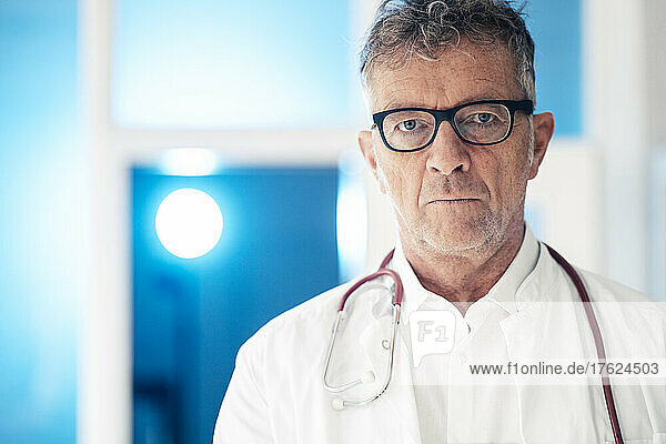 Doctor in eyeglasses standing with stethoscope at clinic