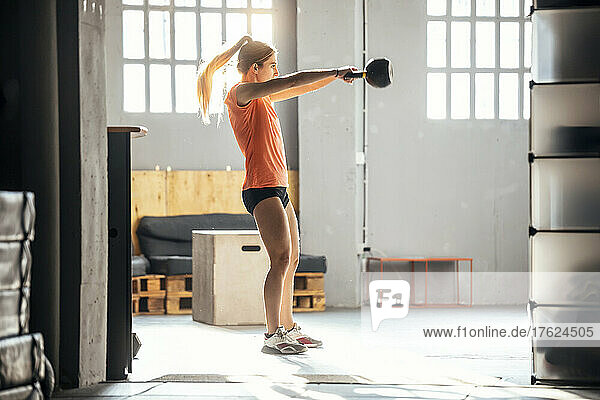 Woman exercising with kettlebells in gym