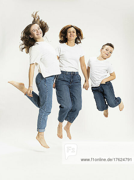 Mother with children jumping against white background