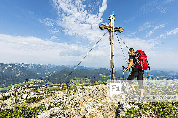 Female hiker standing in front of Bockstein summit cross