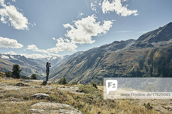 Tourist looking at Timmelsjoch mountain pass on vacation  Otztal Alps  Austria